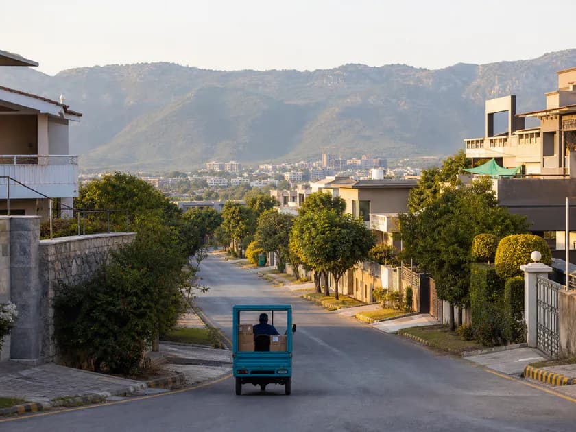 A delivery vehicle in an Islamabad neighborhood near the Margalla Hills